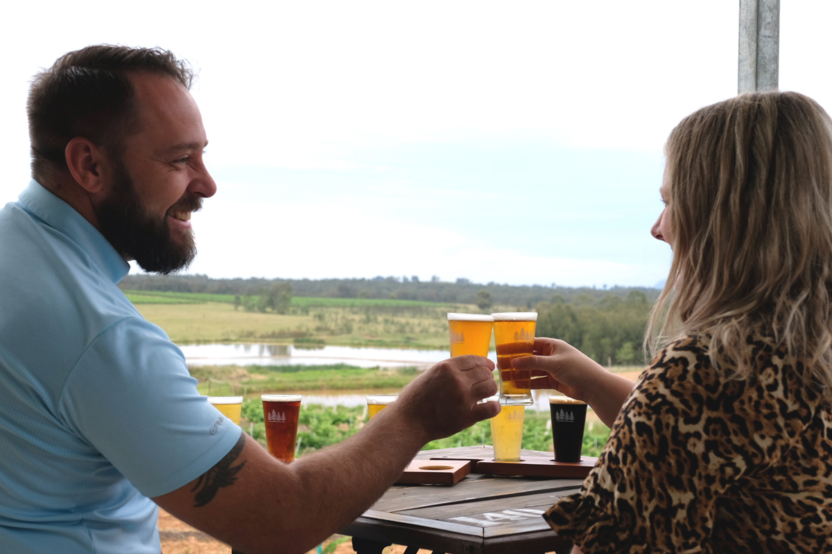 Friends enjoying drinks on the balcony at 4 Pines at the Farm in the Hunter Valley