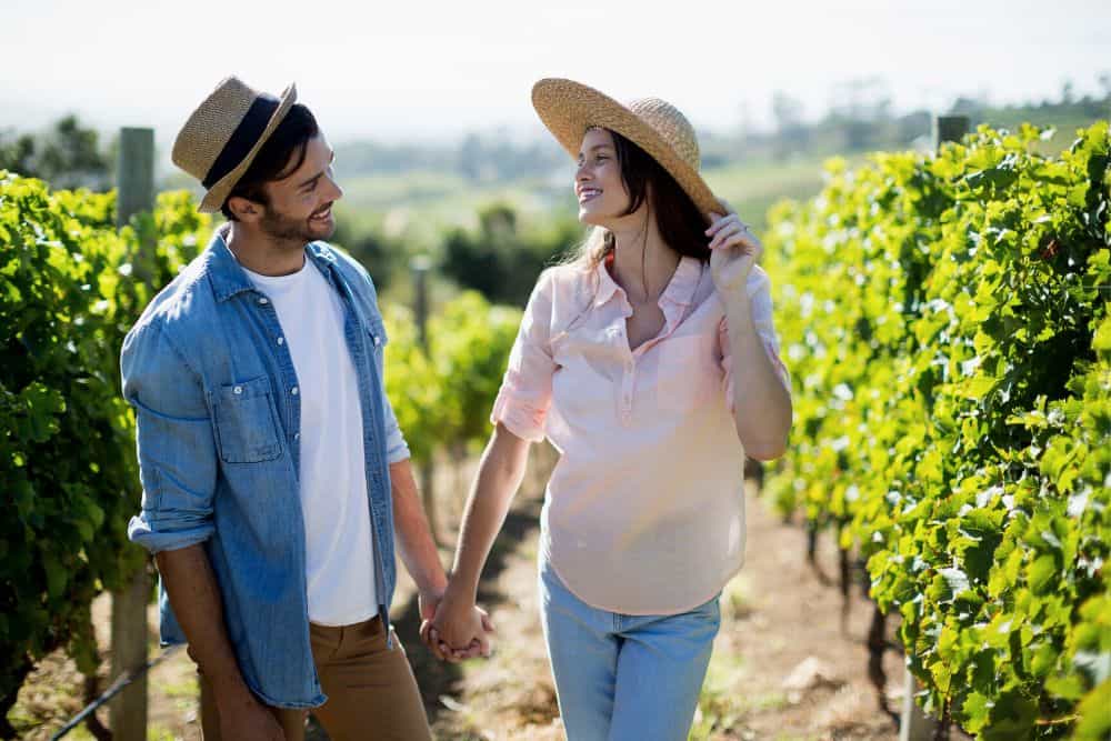 Couple walking through a vineyard during a Hunter Valley getaway in Pokolbin